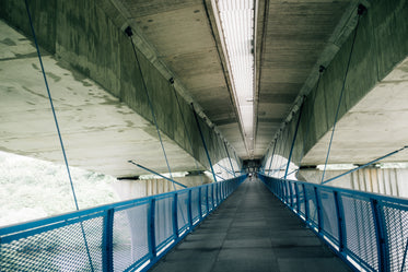 blue metal walkway attached to the concrete ceiling with wire