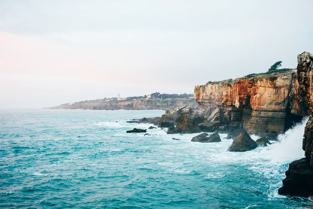 blue sea crashes against yellowstone cliffs