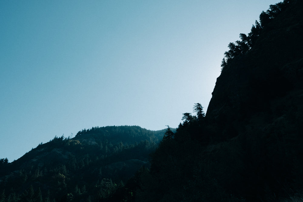 blue skies over rocky hill silhouette