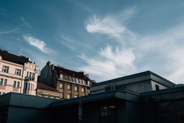 blue skies with wispy clouds over building rooftops