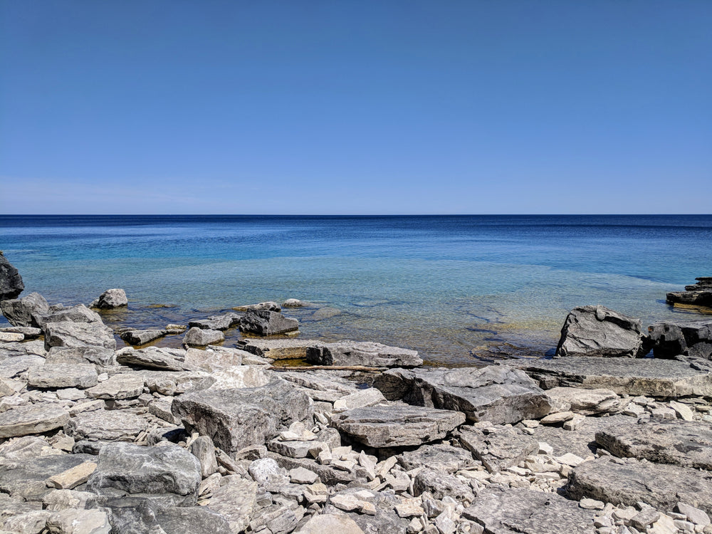 blue sky clear water and rocky shore