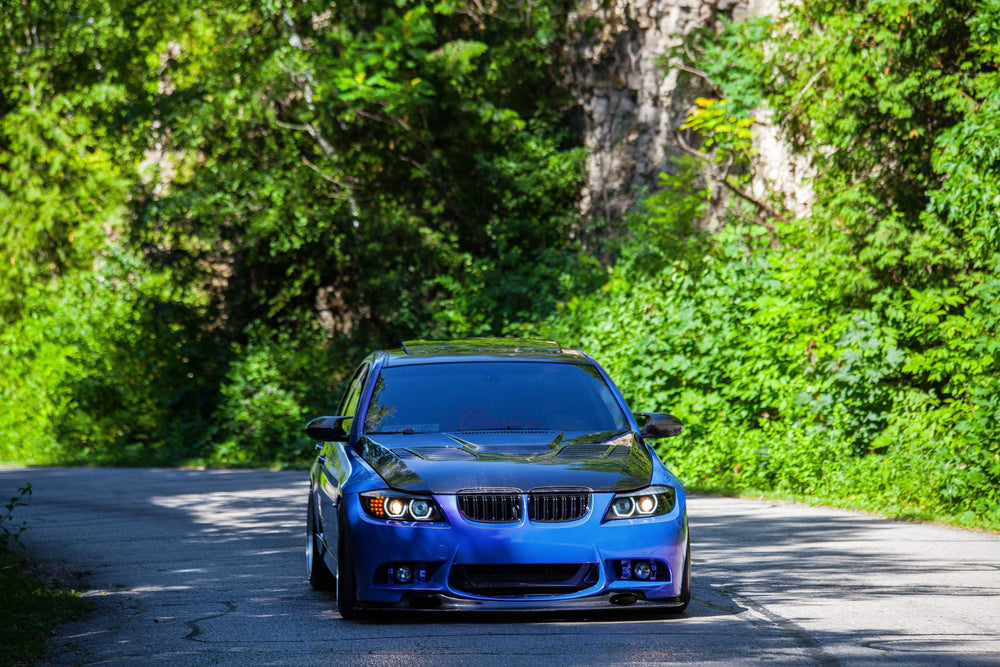 blue sports car drives along country road