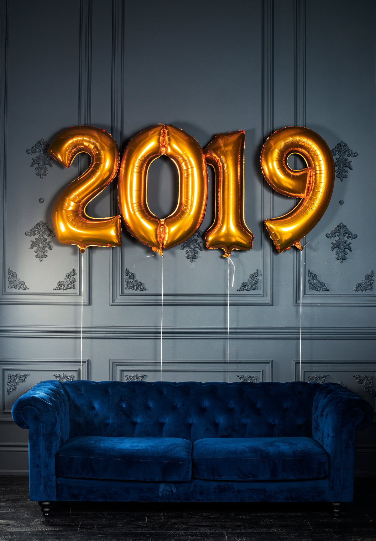 blue velvet couch with helium 2019 balloons