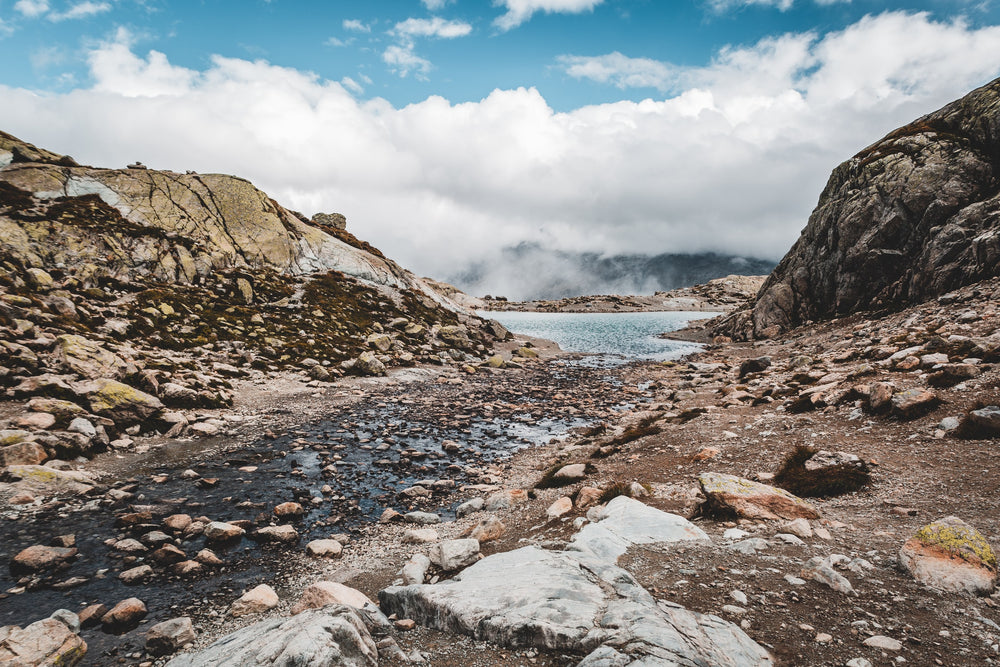 blue water and the rocky shore below low clouds