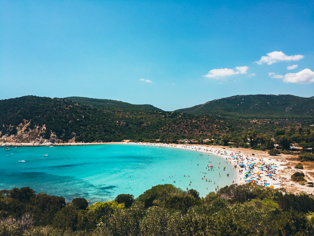 blue water bay with busy beach