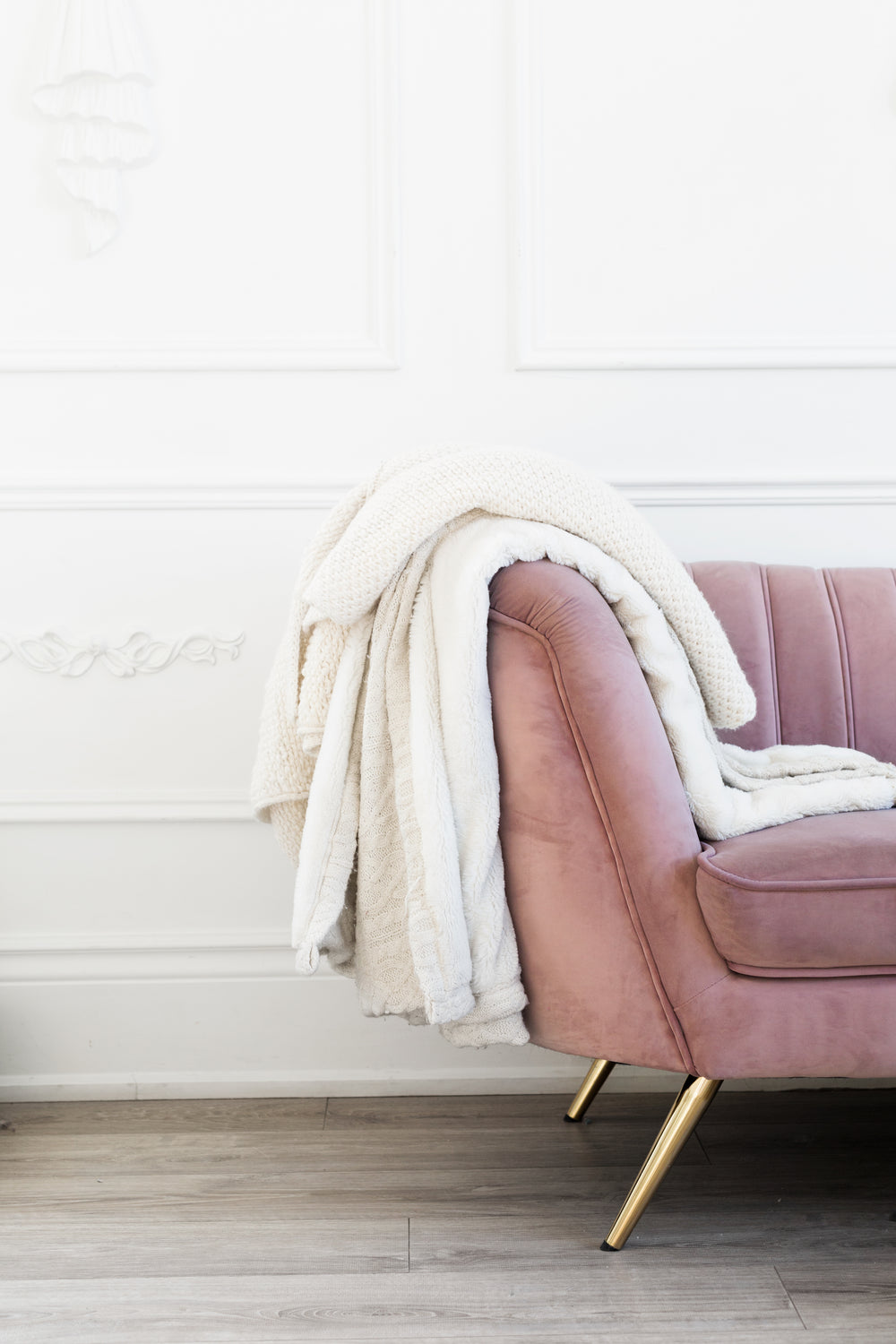sofá rosa vintage com mantas