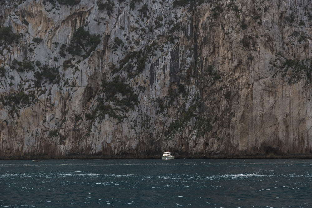boat in front of huge cliff