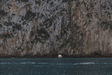 boat in front of huge cliff