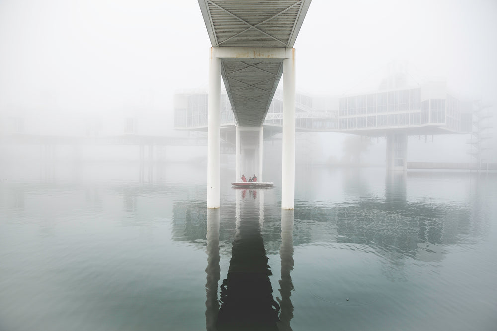 boat under foggy bridge