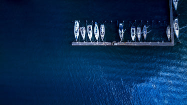 boats docked by wooden pier