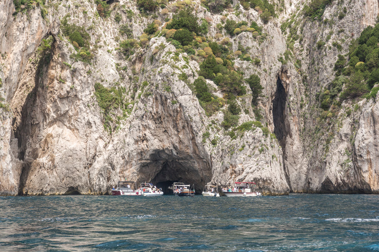 boats-gathered-in-front-of-cave.jpg?widt