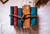 books bound together with twine on a white cloth