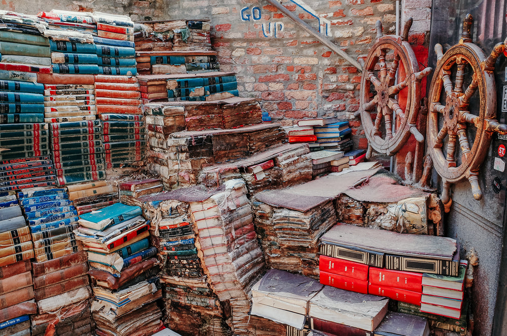 books stacked high against a brick wall