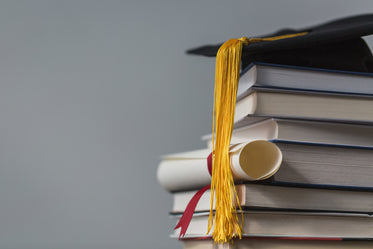 books with graduation cap and diploma