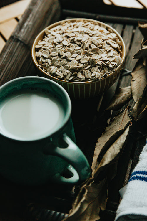 bowl of oats and a mug of tea on a wooden tray