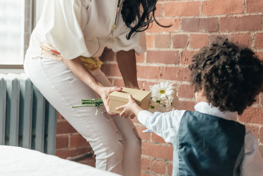 boy giving mom gifts for mothers day