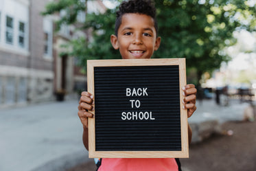 boy holds back to school pegboard