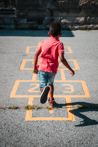 boy plays hopscotch