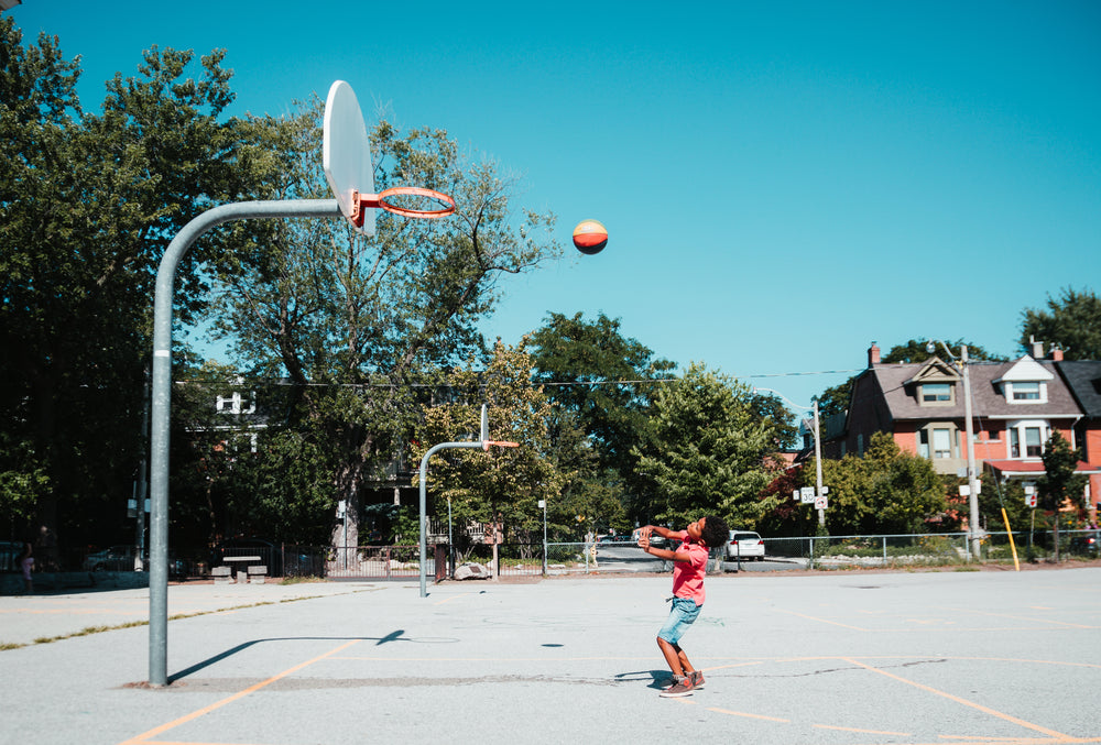 boy throws basketball