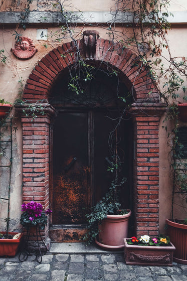 brick archway with plants and flower boxes