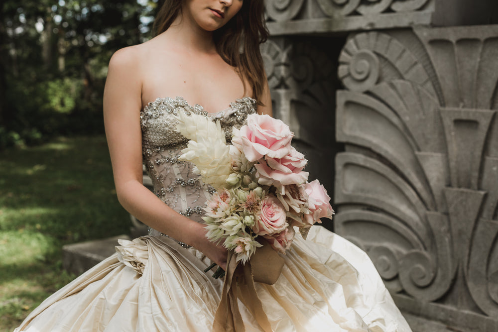 bride holding flowers in sculpture garden