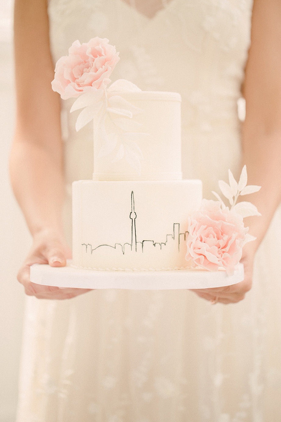 bride holding out white wedding cake