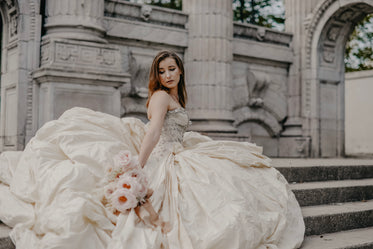 bride in flowing gown climbs steps