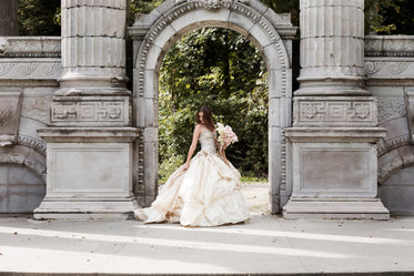 bride in wedding dress near archway