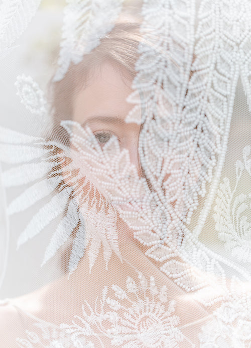 bride peeks through lace veil