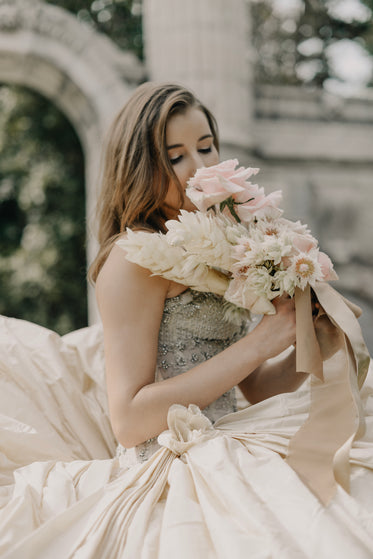 bride smells flowers on wedding day
