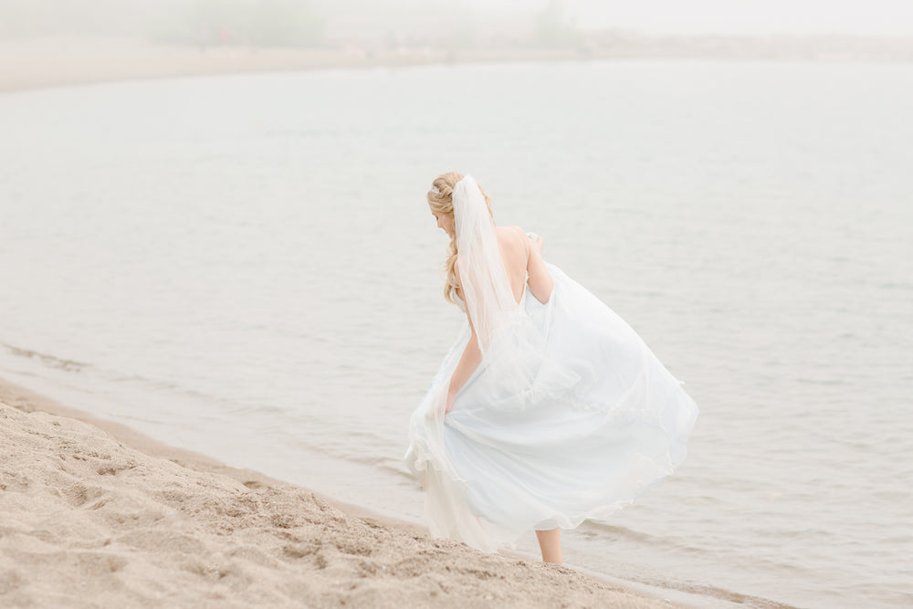 Bride Taking A Walk Along The Beach