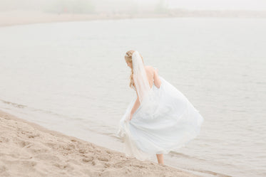 Bride Taking A Walk Along The Beach