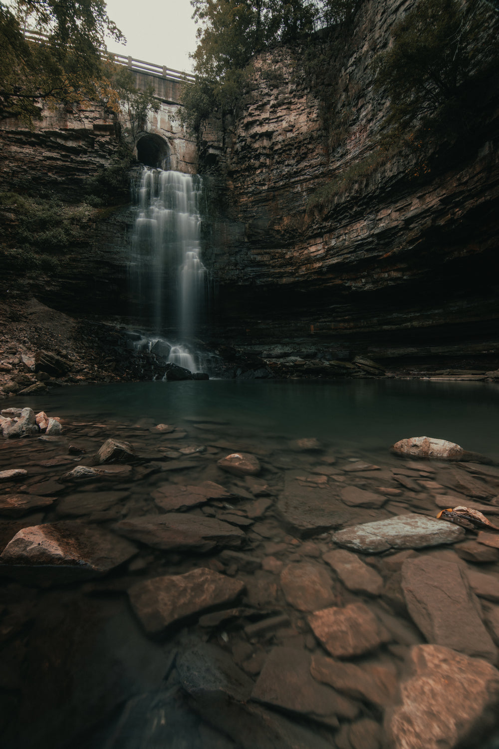 bridge overlooking steep rocks and waterfall