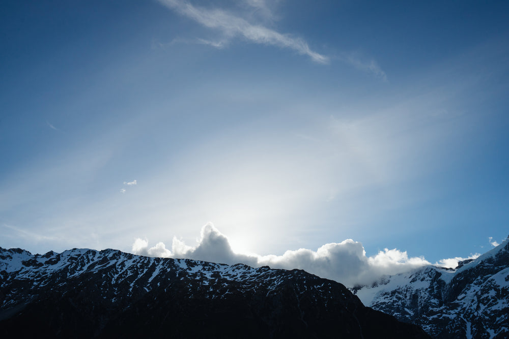 bright blue sky over clouds touching mountiantops