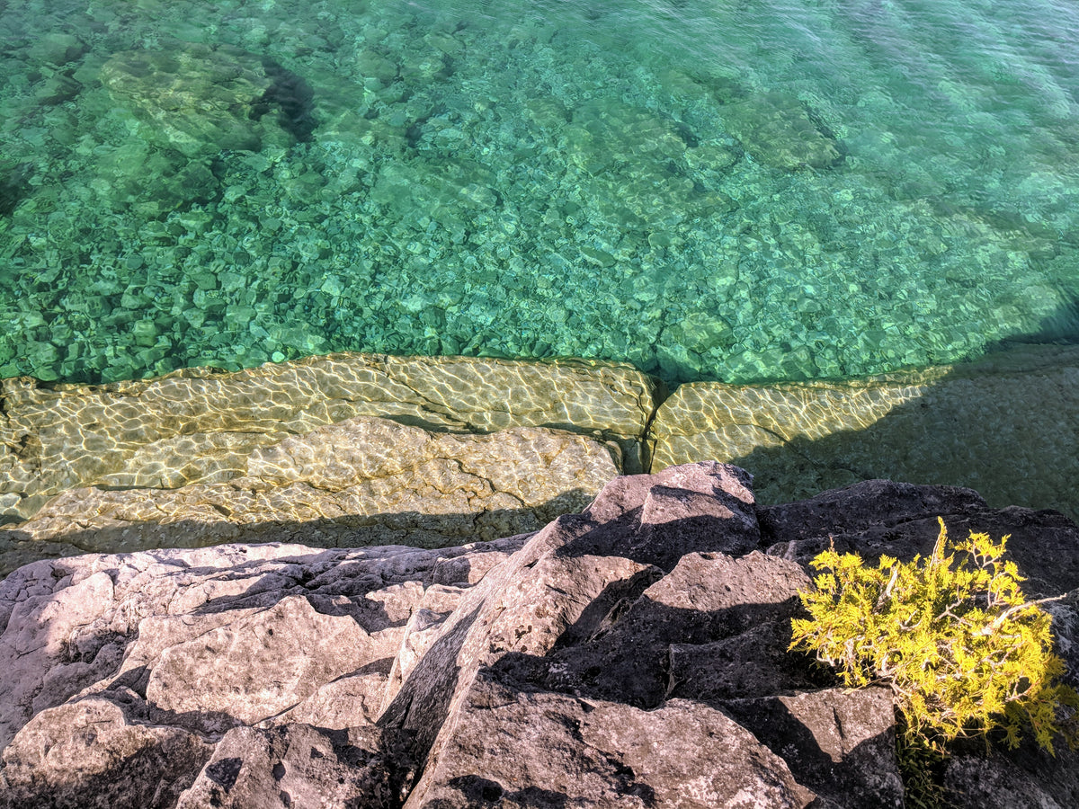 bright clear water by rocky shore