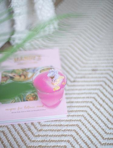 bright pink beverage sits on top of a closed book