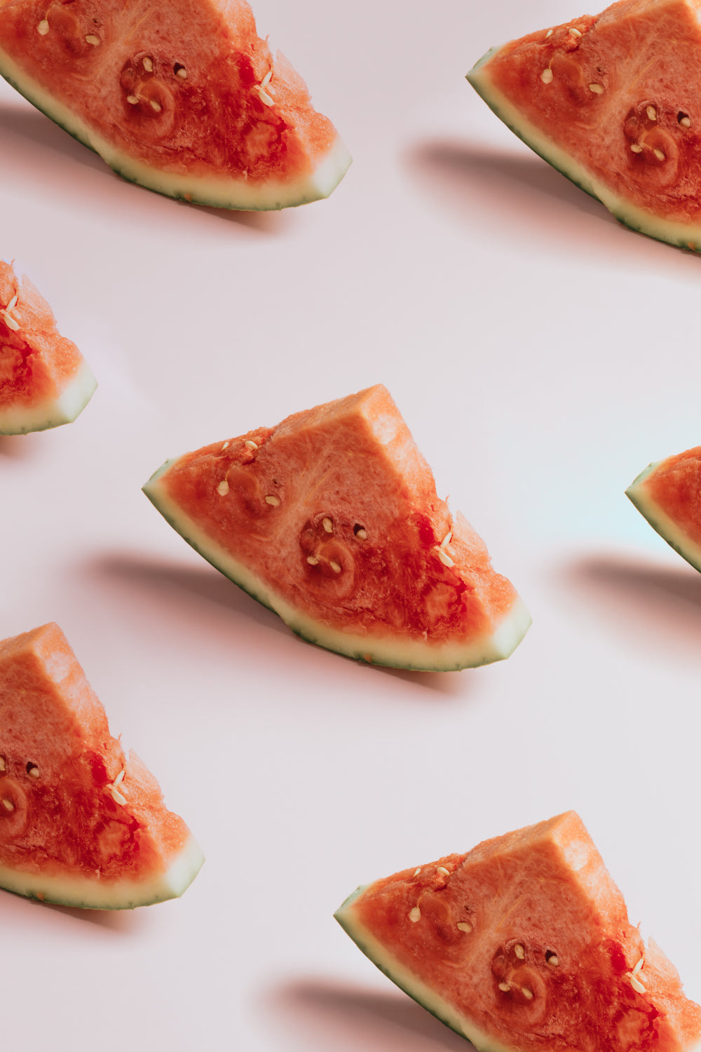 bright red watermelon slices on pink background