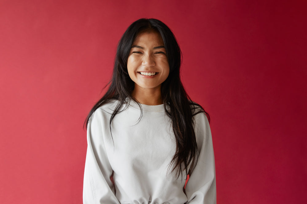 bright smile in front of red background