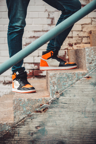 bright sneakers and dark denim atop urban stairwell
