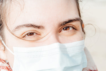 brown eyes of a person wearing a face mask