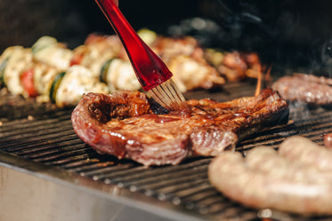 brushing bbq sauce on grilled steak