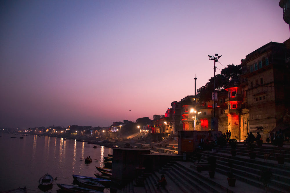 building lined waterfront below a sunset