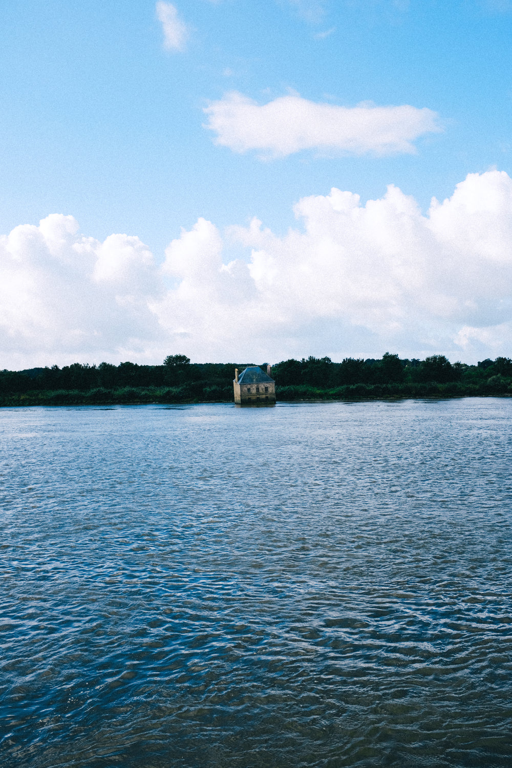 building sinking into blue water