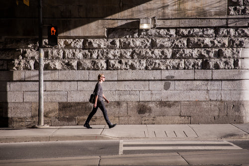 business man walks in urban sunlight