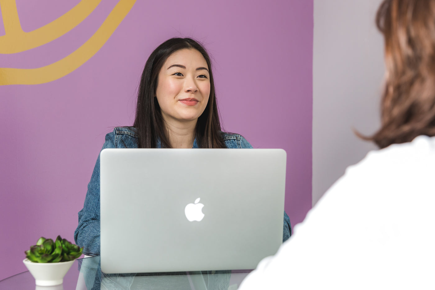 A professional reviewing information on a laptop during a meeting