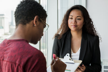 business woman looking at man with clipboard