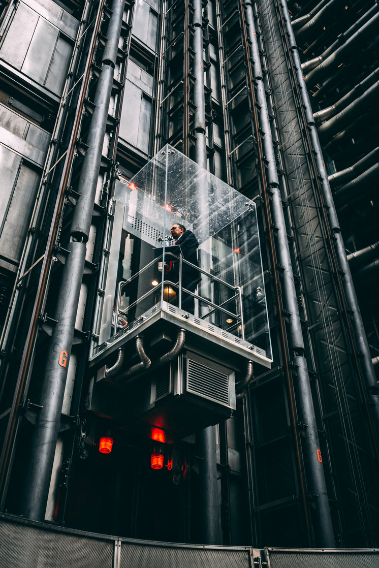 Businessman In Glass Elevator Going Up