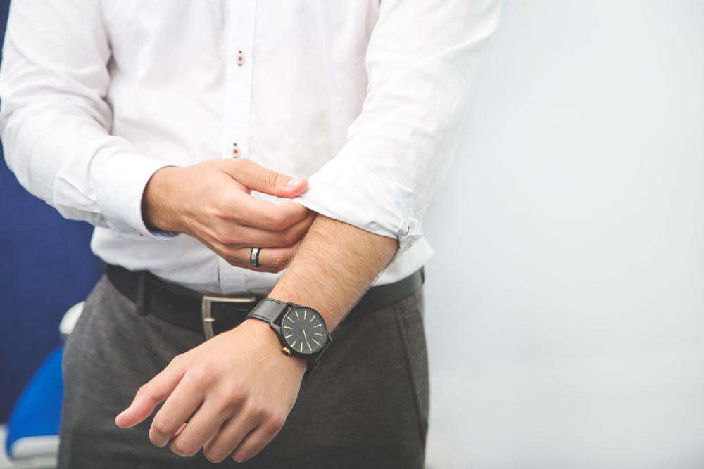 businessman rolls up sleeve