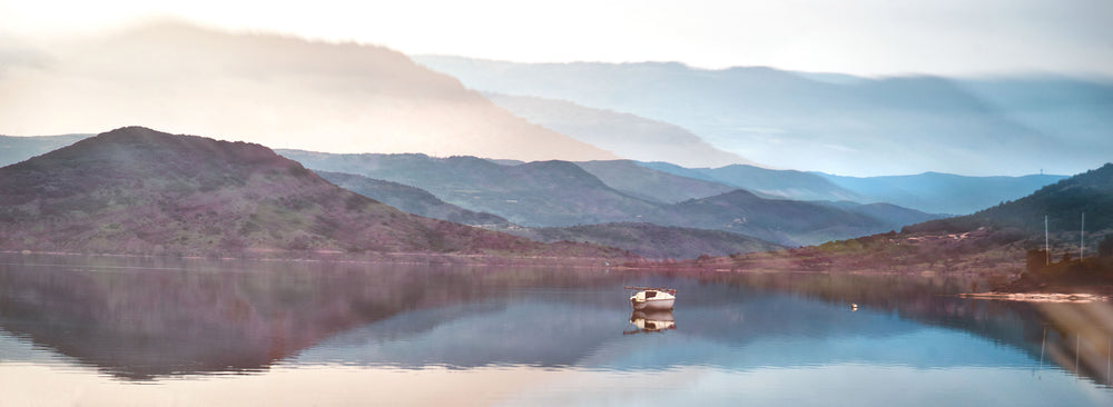 calm glass like water with rolling hills behind