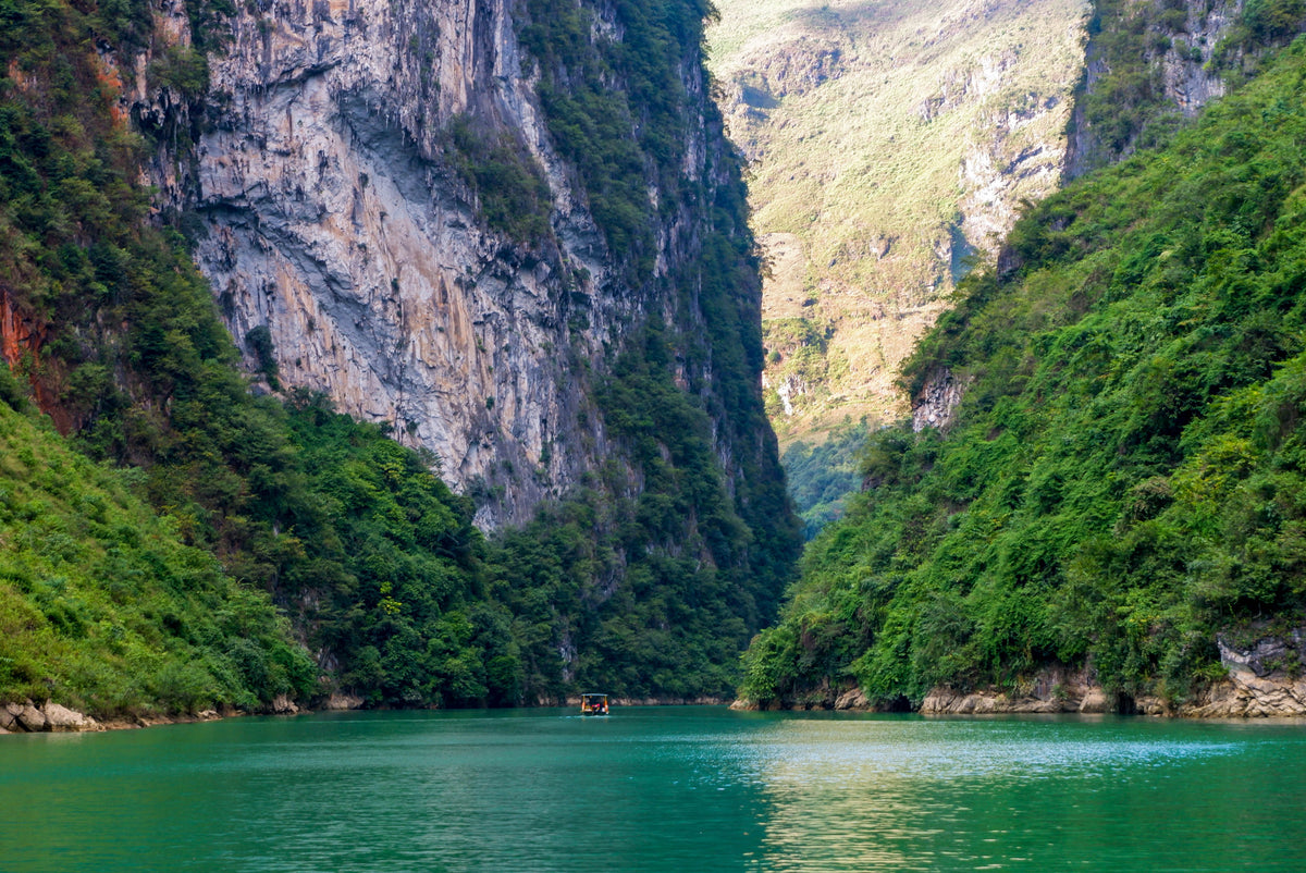 calm water beneath an expanse of green mountains